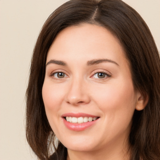 Joyful white young-adult female with long  brown hair and brown eyes