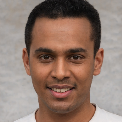 Joyful latino young-adult male with short  black hair and brown eyes