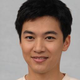 Joyful asian young-adult male with short  brown hair and brown eyes