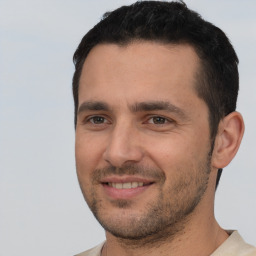 Joyful white young-adult male with short  black hair and brown eyes