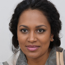 Joyful black young-adult female with long  brown hair and brown eyes