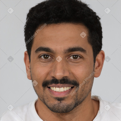 Joyful latino young-adult male with short  black hair and brown eyes