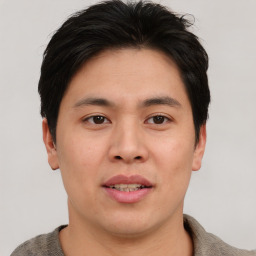 Joyful asian young-adult male with short  brown hair and brown eyes