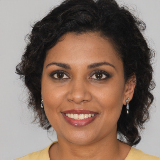 Joyful black young-adult female with medium  brown hair and brown eyes