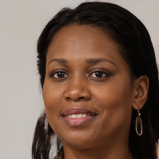 Joyful black adult female with long  brown hair and brown eyes