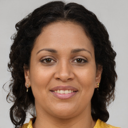 Joyful latino adult female with long  brown hair and brown eyes