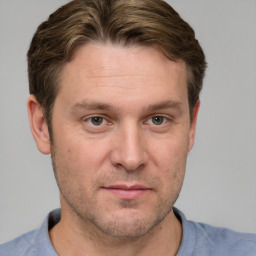 Joyful white adult male with short  brown hair and grey eyes