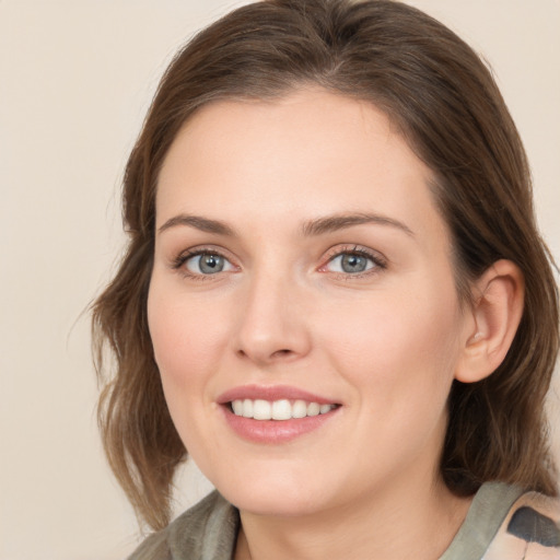 Joyful white young-adult female with medium  brown hair and blue eyes