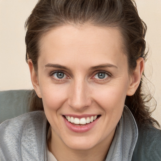 Joyful white young-adult female with medium  brown hair and grey eyes