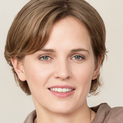 Joyful white young-adult female with medium  brown hair and grey eyes