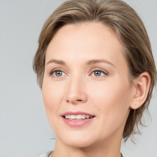 Joyful white young-adult female with medium  brown hair and grey eyes