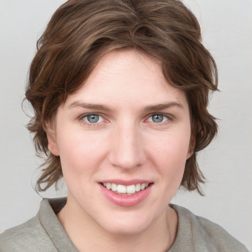 Joyful white young-adult female with medium  brown hair and blue eyes