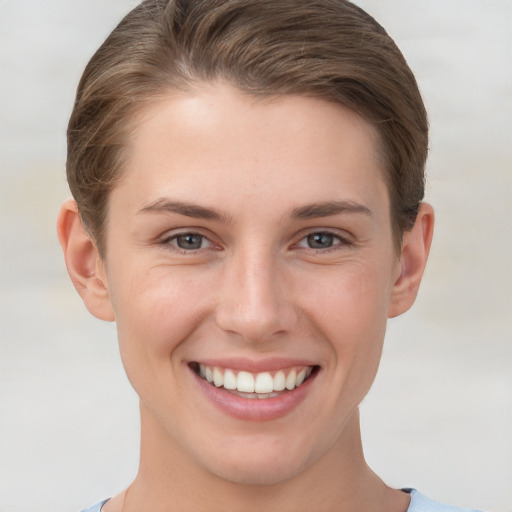 Joyful white young-adult female with short  brown hair and grey eyes