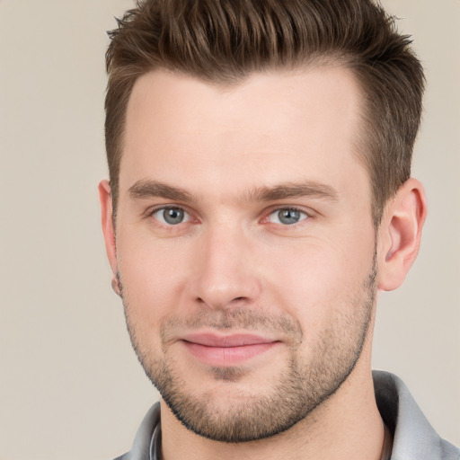 Joyful white young-adult male with short  brown hair and grey eyes