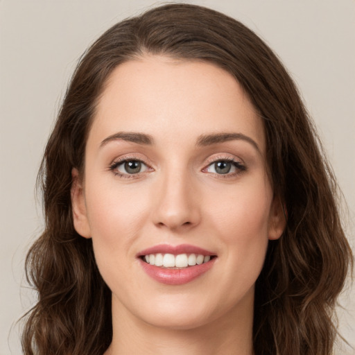 Joyful white young-adult female with long  brown hair and green eyes