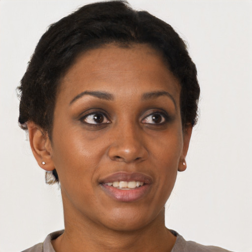 Joyful black young-adult female with short  brown hair and brown eyes