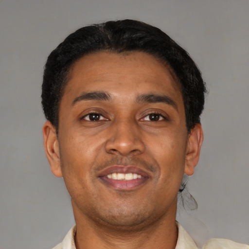 Joyful latino young-adult male with short  brown hair and brown eyes