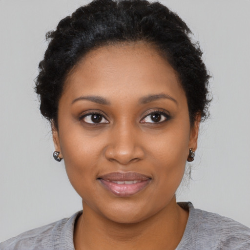 Joyful black young-adult female with short  black hair and brown eyes