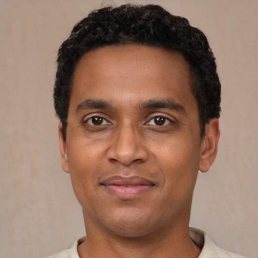 Joyful black young-adult male with short  black hair and brown eyes