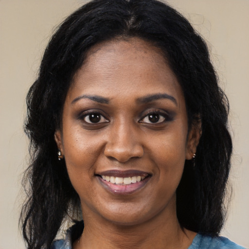 Joyful black young-adult female with long  black hair and brown eyes