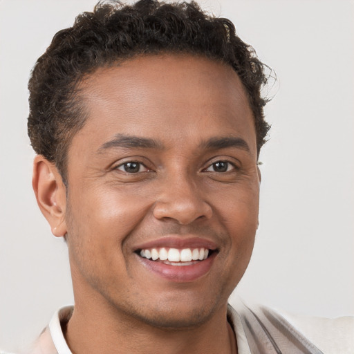 Joyful black young-adult male with short  brown hair and brown eyes