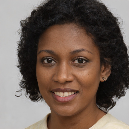 Joyful black young-adult female with long  brown hair and brown eyes