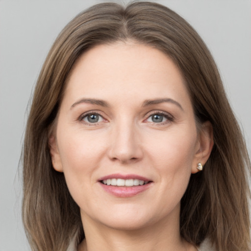 Joyful white adult female with long  brown hair and grey eyes