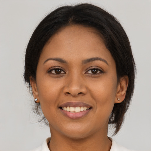 Joyful black young-adult female with medium  brown hair and brown eyes
