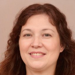 Joyful white adult female with long  brown hair and brown eyes