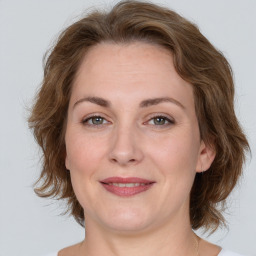 Joyful white young-adult female with medium  brown hair and green eyes