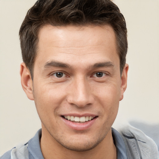 Joyful white young-adult male with short  brown hair and brown eyes