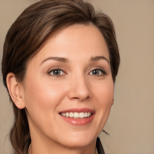 Joyful white young-adult female with medium  brown hair and grey eyes