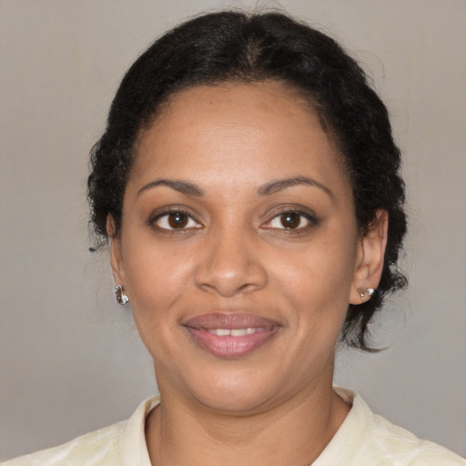 Joyful black adult female with medium  brown hair and brown eyes
