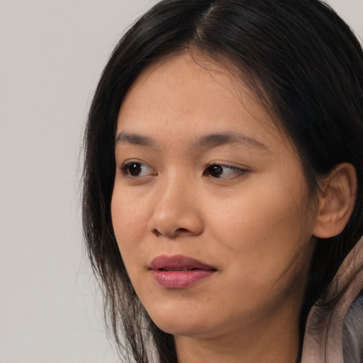 Joyful asian young-adult female with long  brown hair and brown eyes