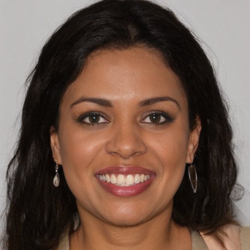 Joyful latino young-adult female with long  brown hair and brown eyes