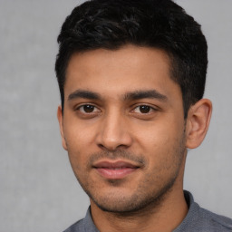 Joyful latino young-adult male with short  black hair and brown eyes