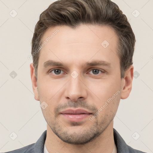 Joyful white young-adult male with short  brown hair and grey eyes