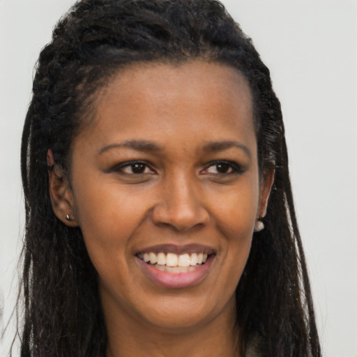 Joyful black young-adult female with long  black hair and brown eyes