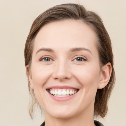 Joyful white young-adult female with medium  brown hair and green eyes