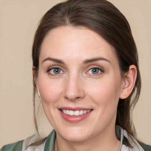 Joyful white young-adult female with medium  brown hair and grey eyes