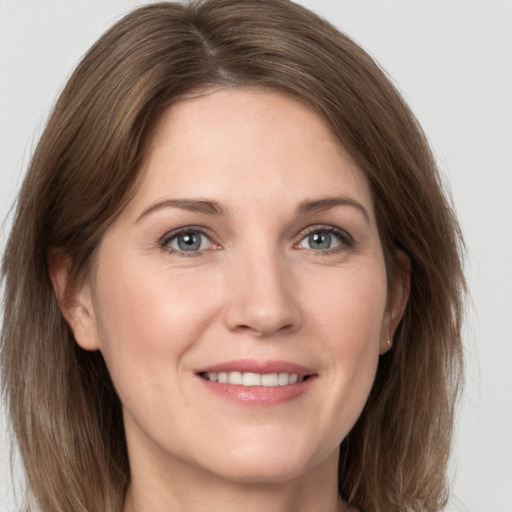 Joyful white young-adult female with medium  brown hair and grey eyes