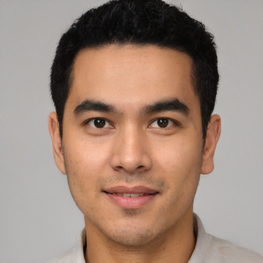 Joyful latino young-adult male with short  black hair and brown eyes