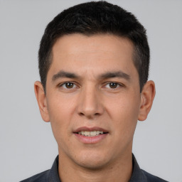 Joyful white young-adult male with short  black hair and brown eyes