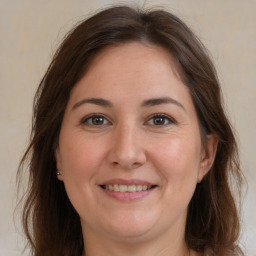 Joyful white adult female with long  brown hair and brown eyes