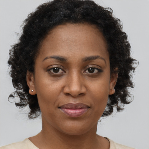 Joyful black adult female with short  brown hair and brown eyes