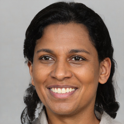 Joyful latino adult female with medium  black hair and brown eyes