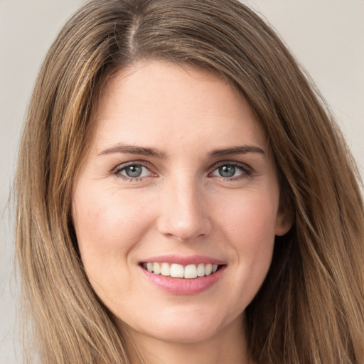 Joyful white young-adult female with long  brown hair and green eyes