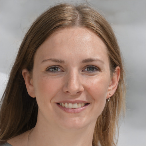 Joyful white young-adult female with medium  brown hair and grey eyes