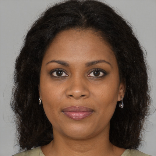 Joyful black young-adult female with long  brown hair and brown eyes
