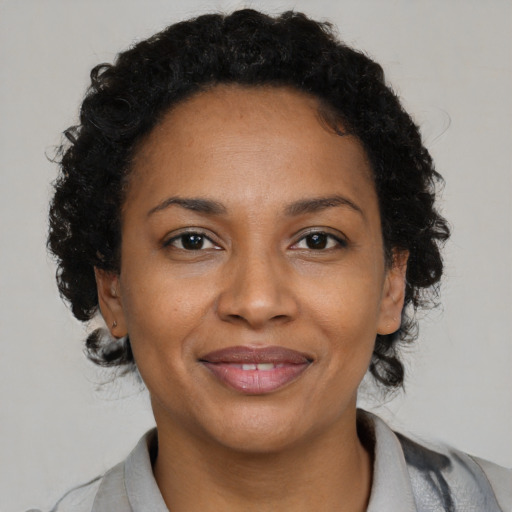 Joyful black adult female with short  brown hair and brown eyes